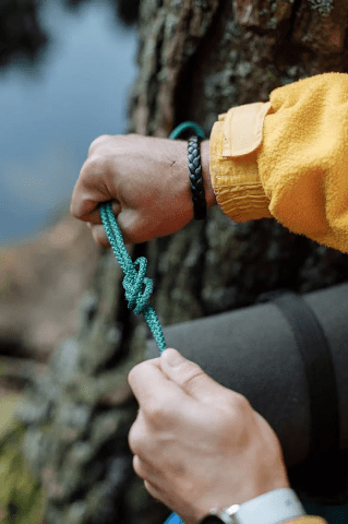 Survival-Bracelet men tying a survival bracelet