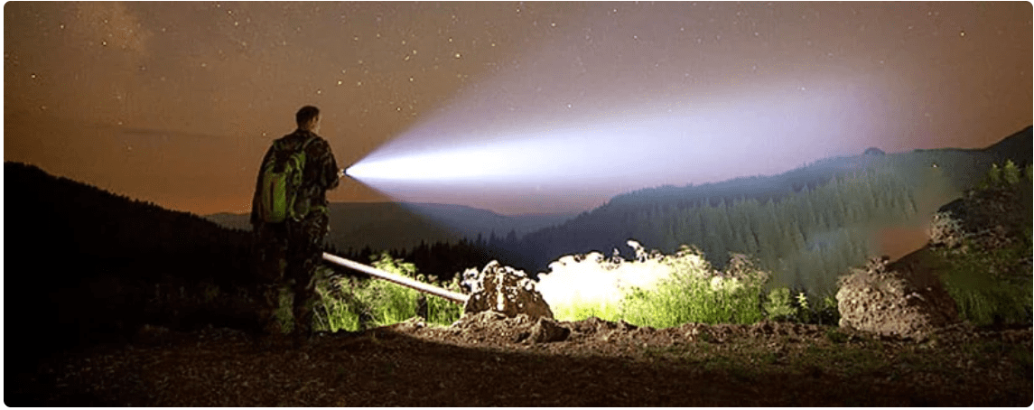 sos-emergency-flashlight a man holding a flashlight and shining it through the valley