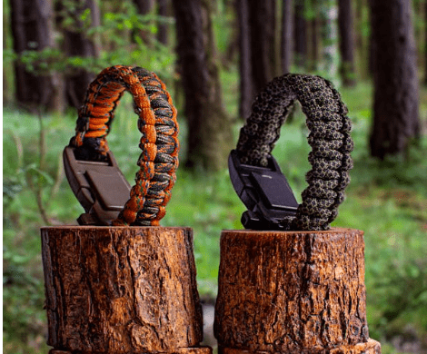 what-are-survival-bracelets-called 2 survival bracelets sitting on a tree stump